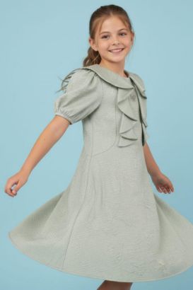 صورة فستان اخظر فاتح كشكشة على الصدر وفينكات فضيه